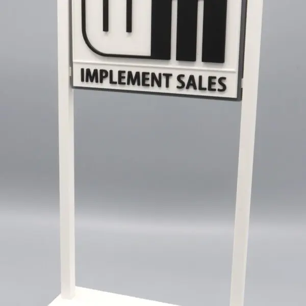 Implement Sales sign on white stand.