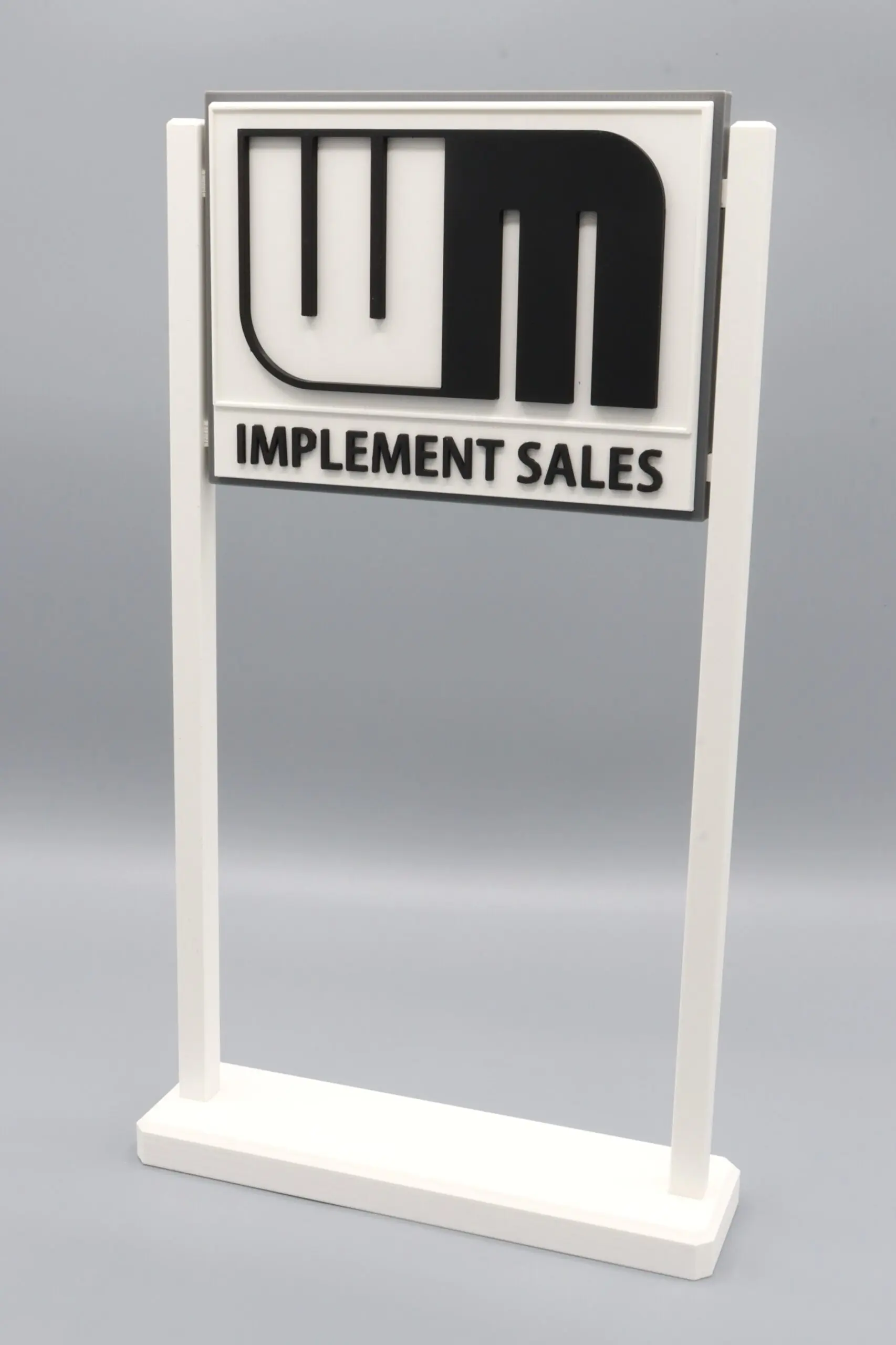 Implement Sales sign on white stand.