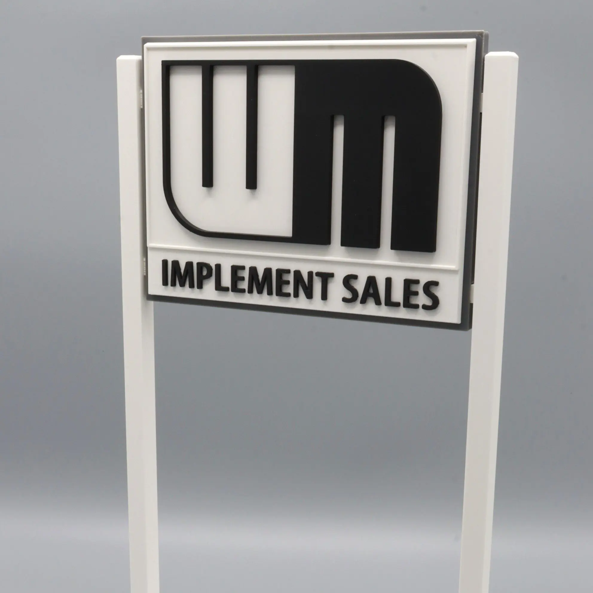 Sign reading "WM Implement Sales" on stand.