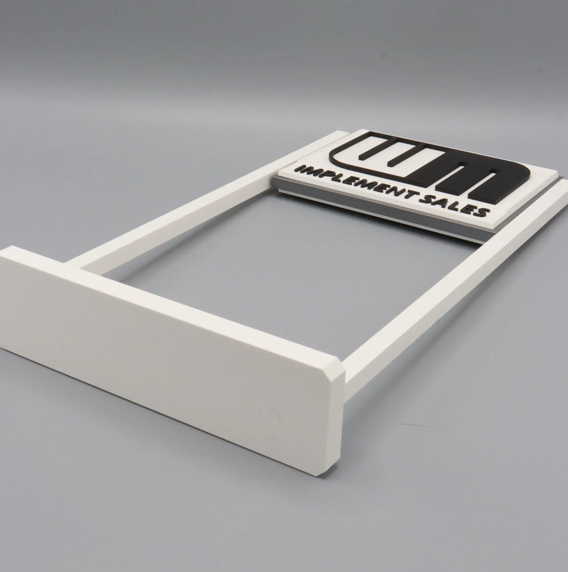 White frame with "IMPLEMENT SALES" text sign.