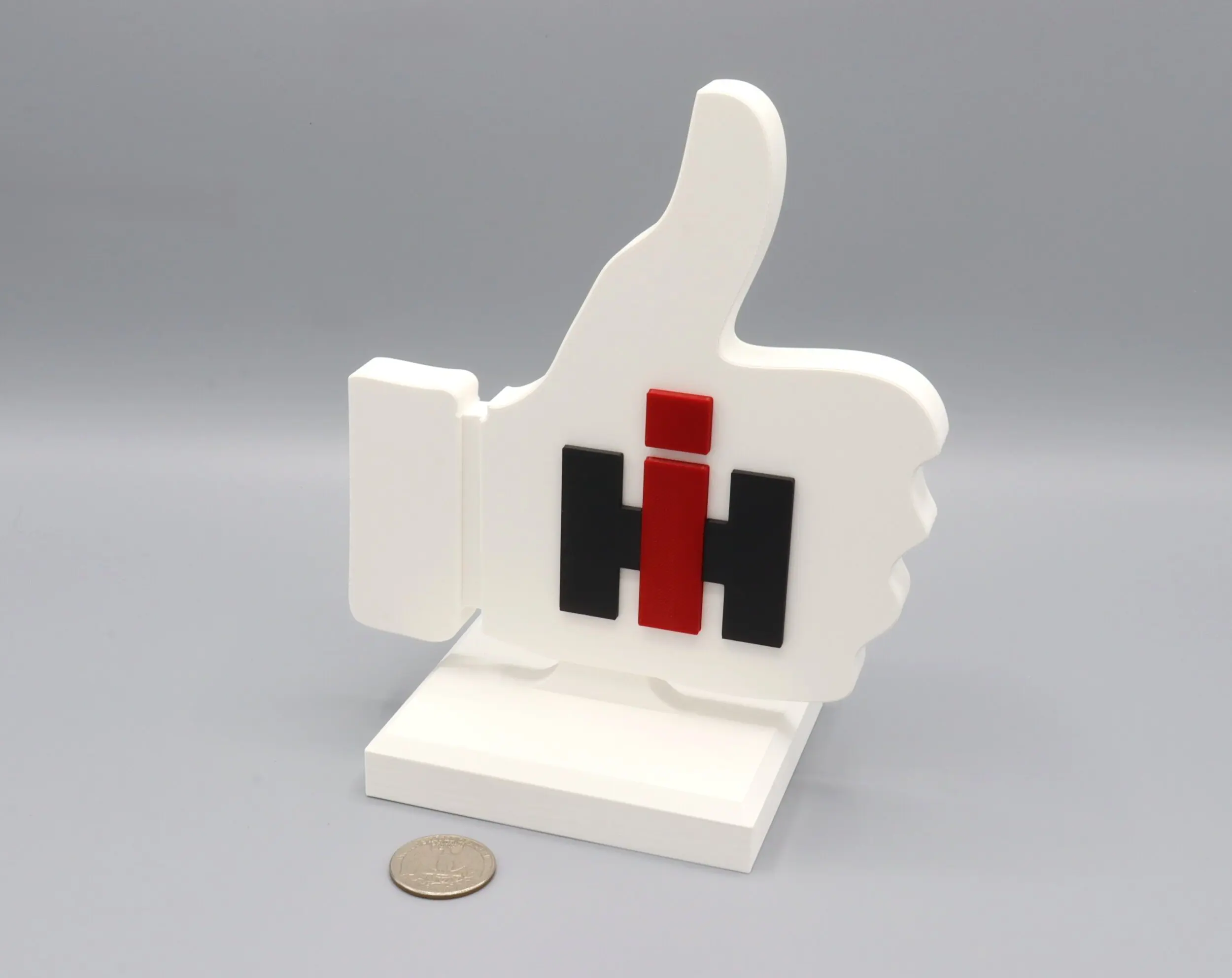Thumbs up sculpture with logo and coin.