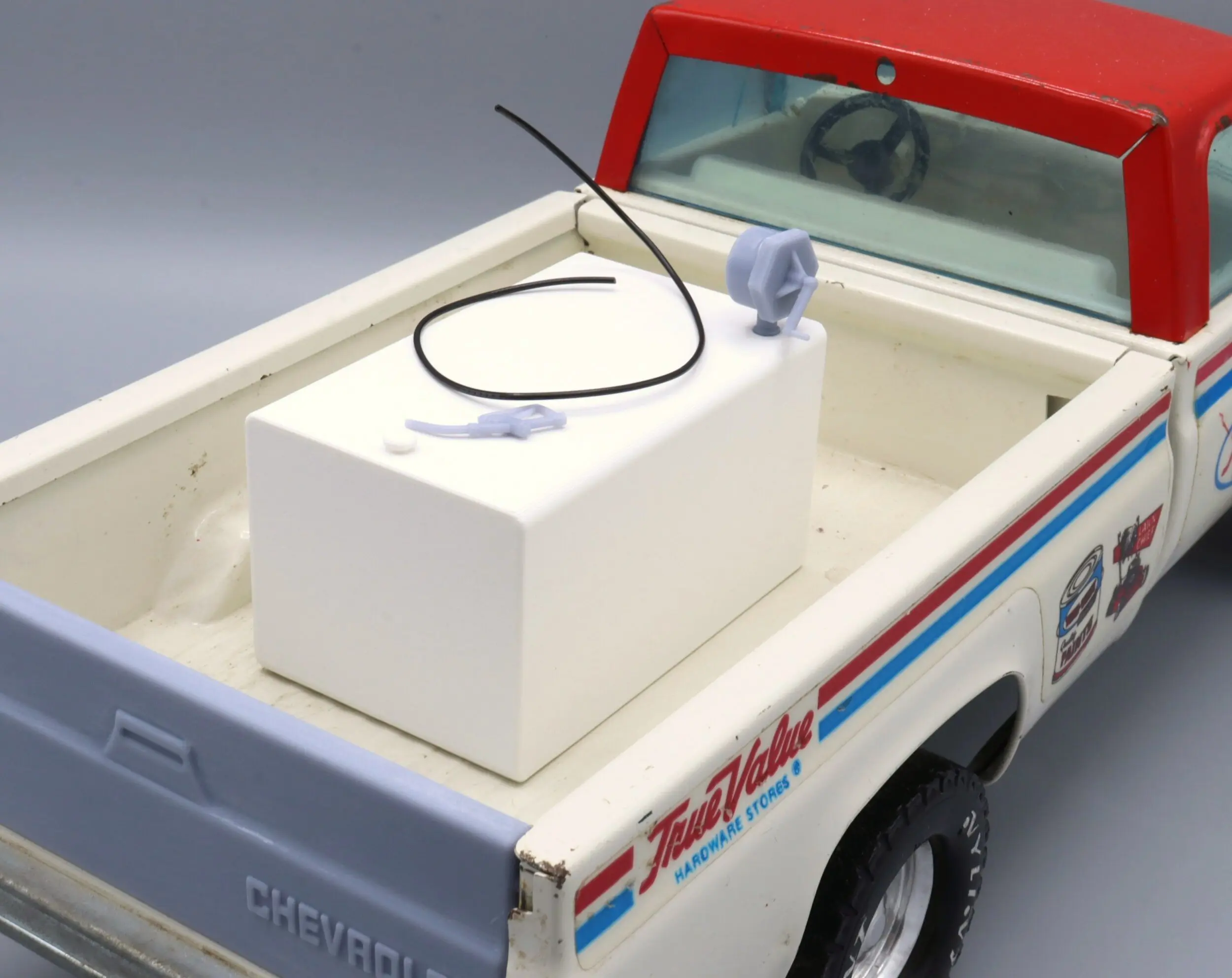 Toy truck with white tank in back.
