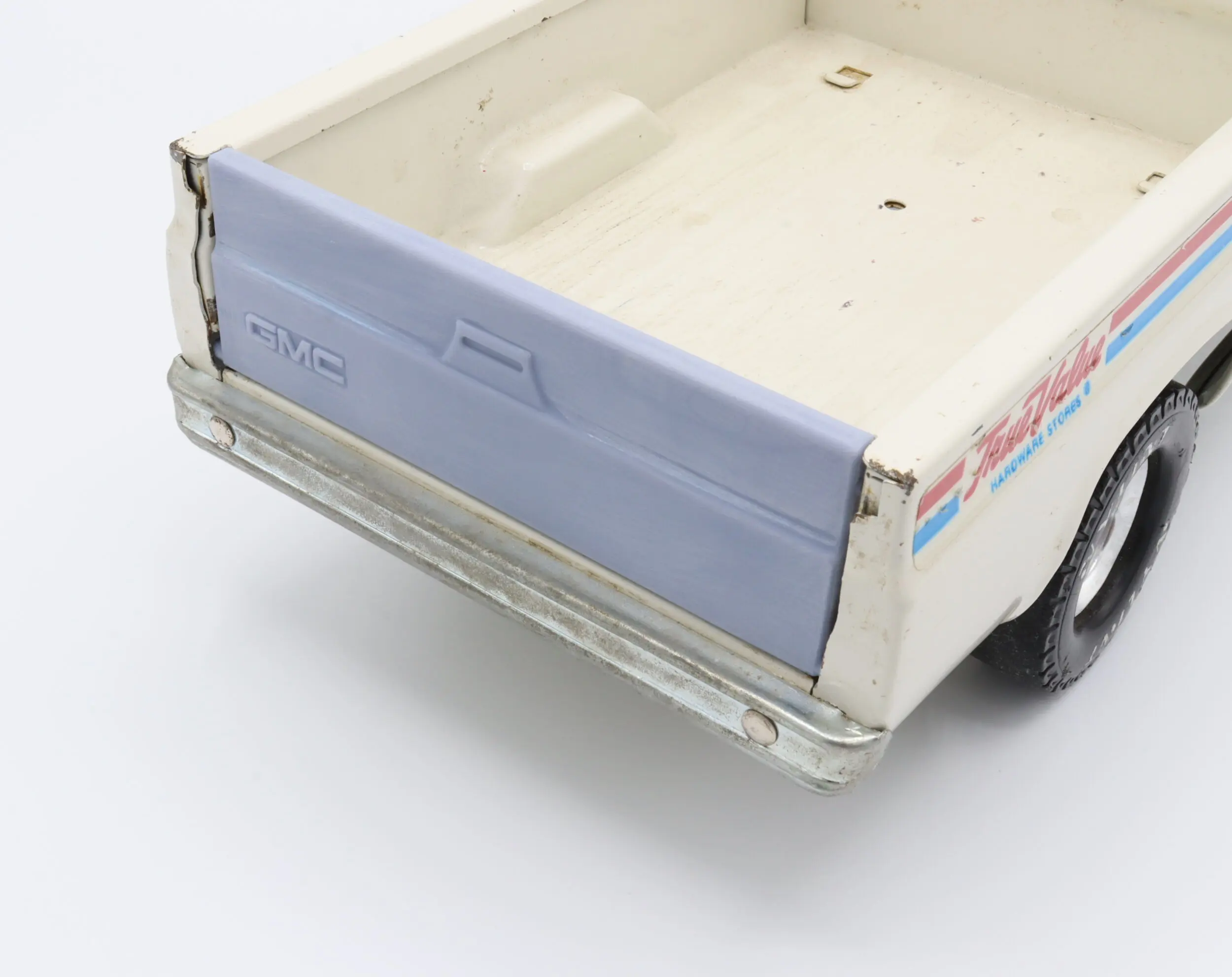 Model toy truck with a blue tailgate.