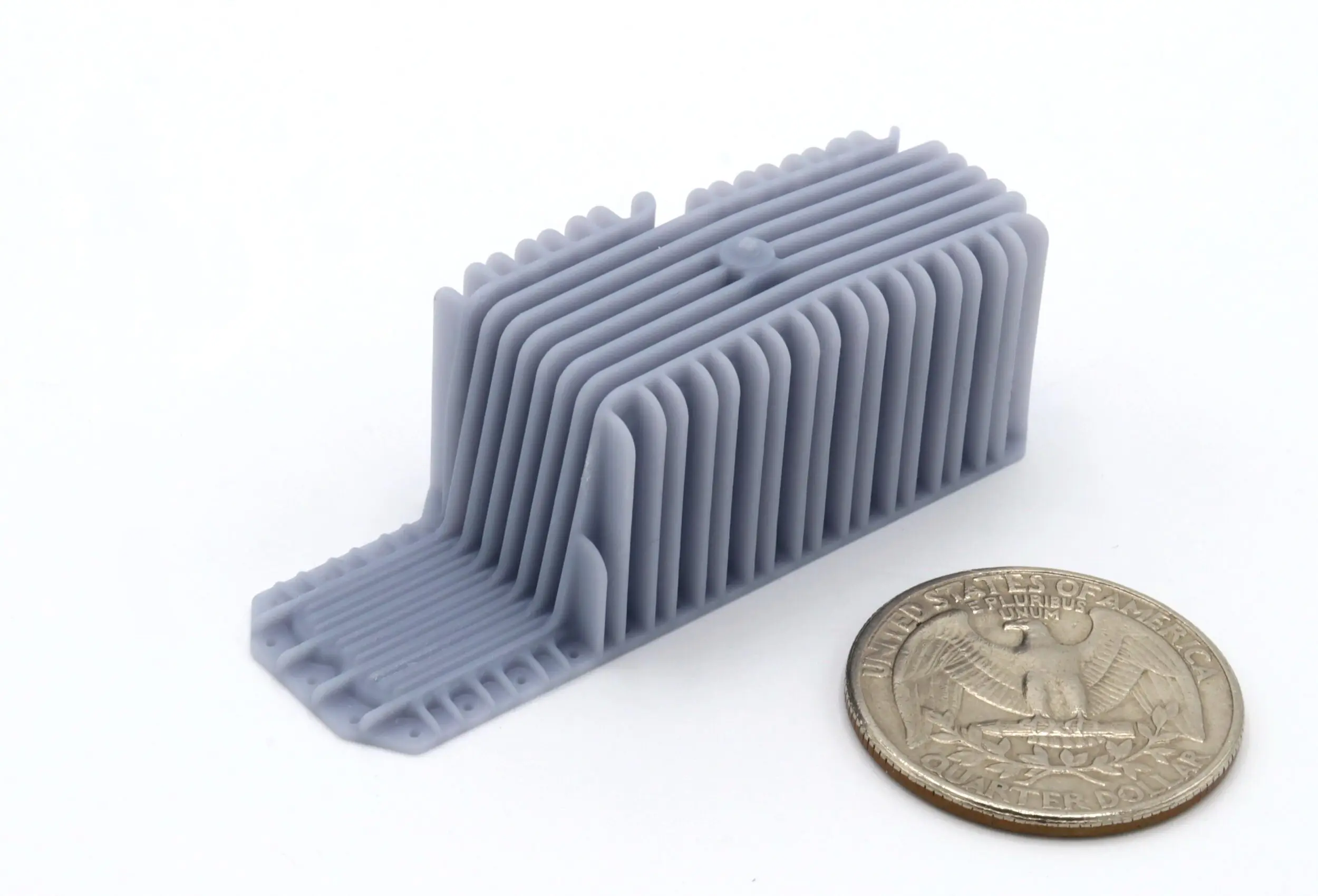 3D-printed object beside a quarter coin.