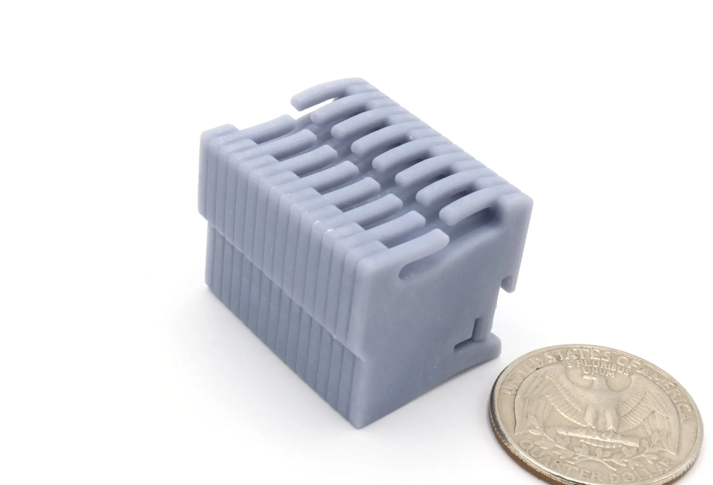 Gray plastic connector beside a coin.