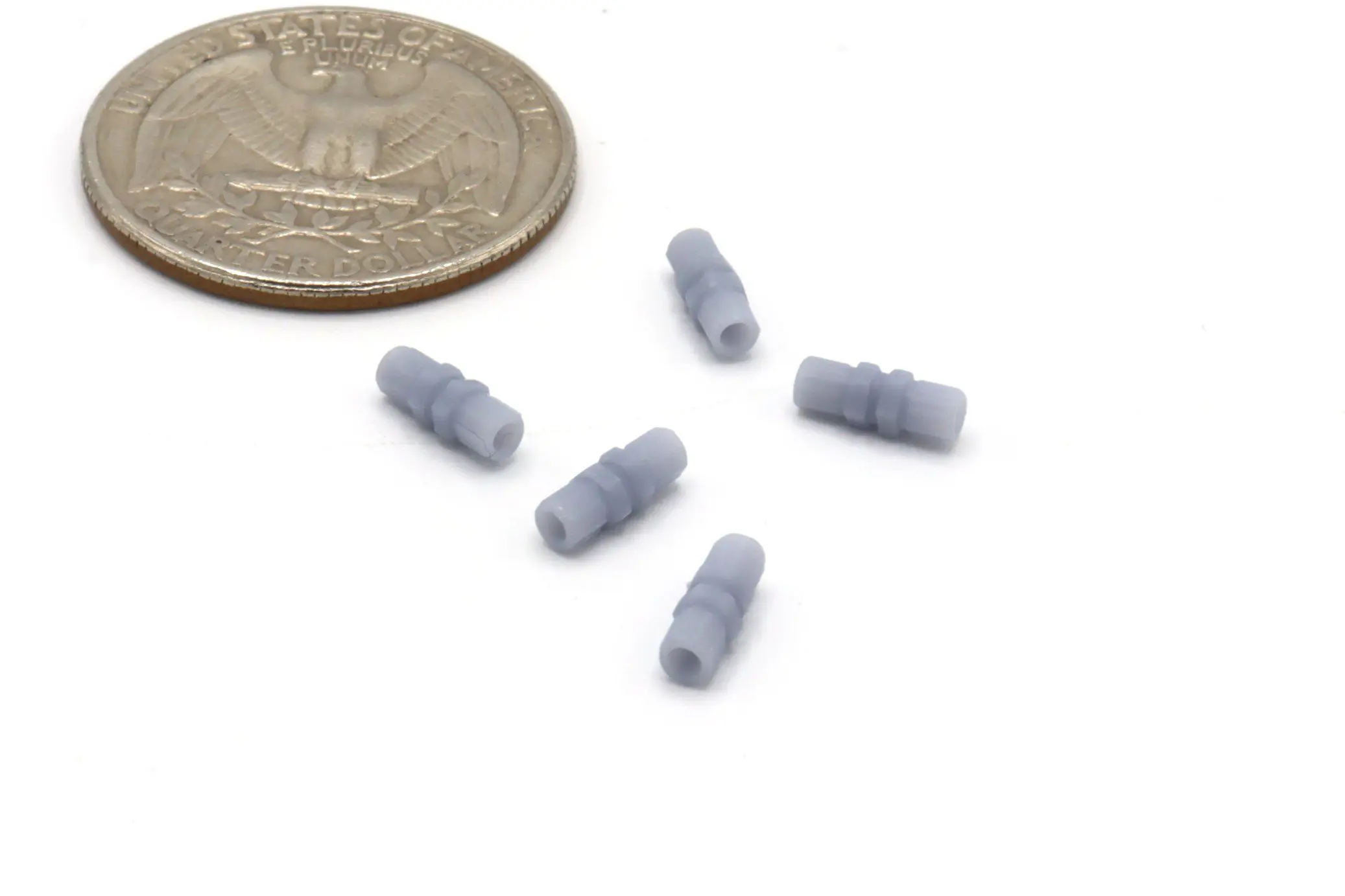 Small gray connectors beside a quarter coin.