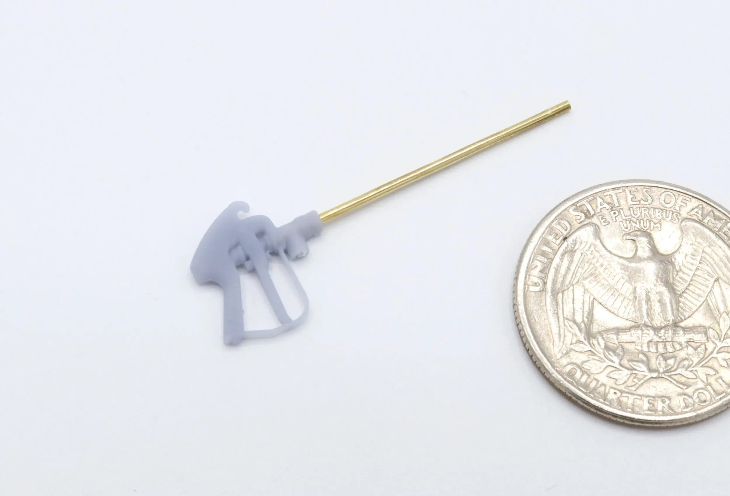 Tiny model gas pump next to coin.