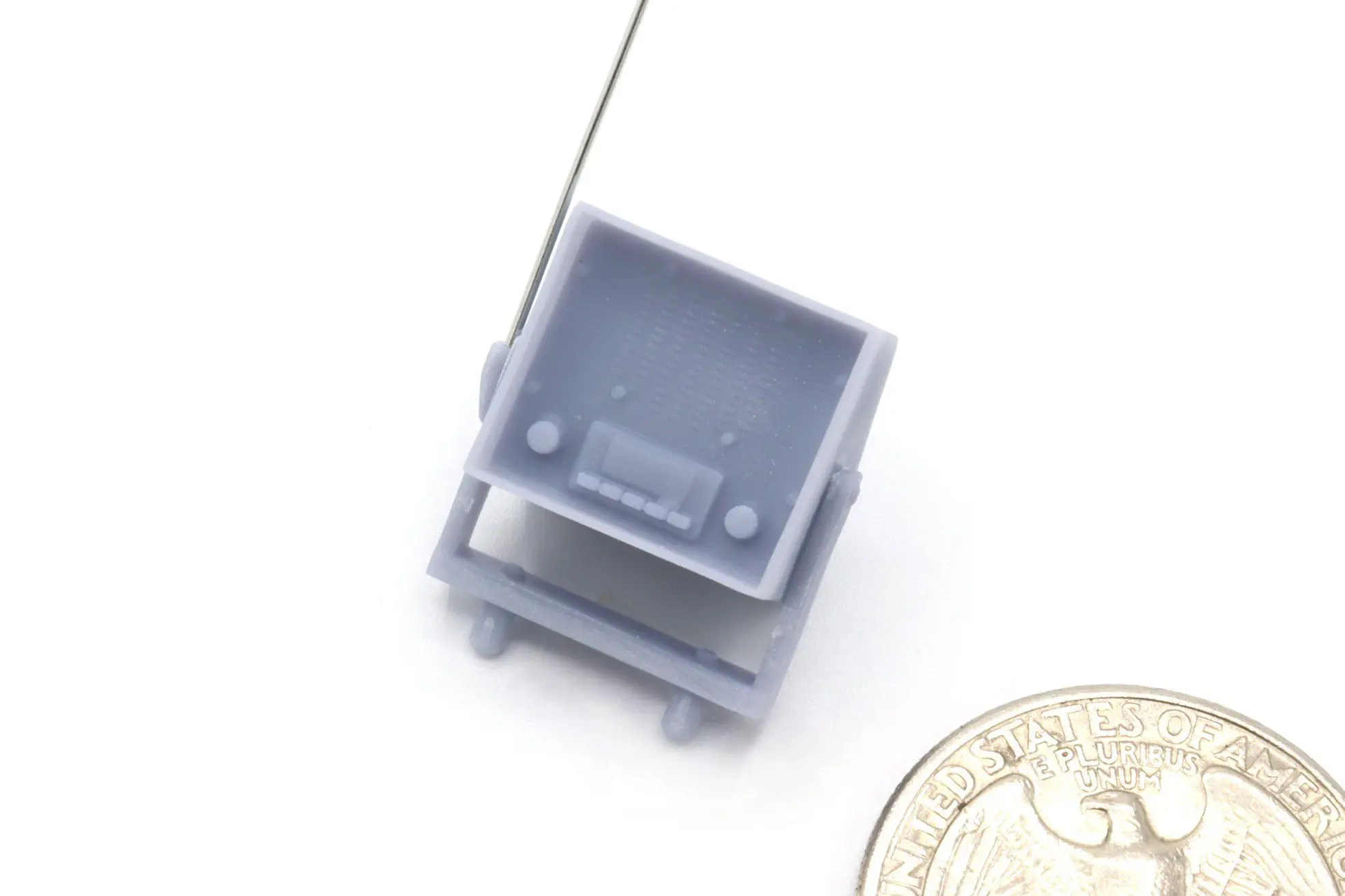 Tiny plastic model with a coin nearby.
