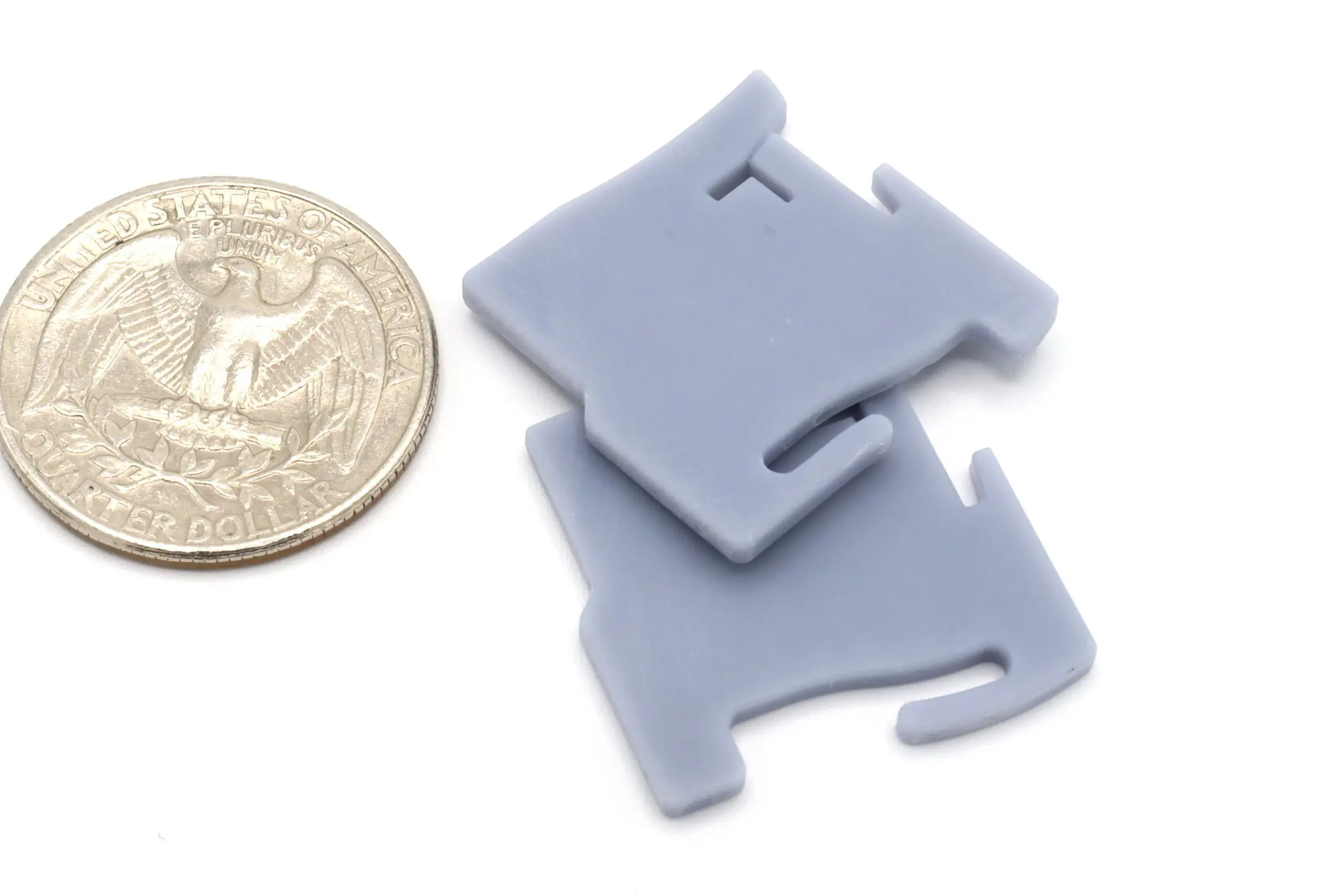 Gray bag clips next to a quarter.