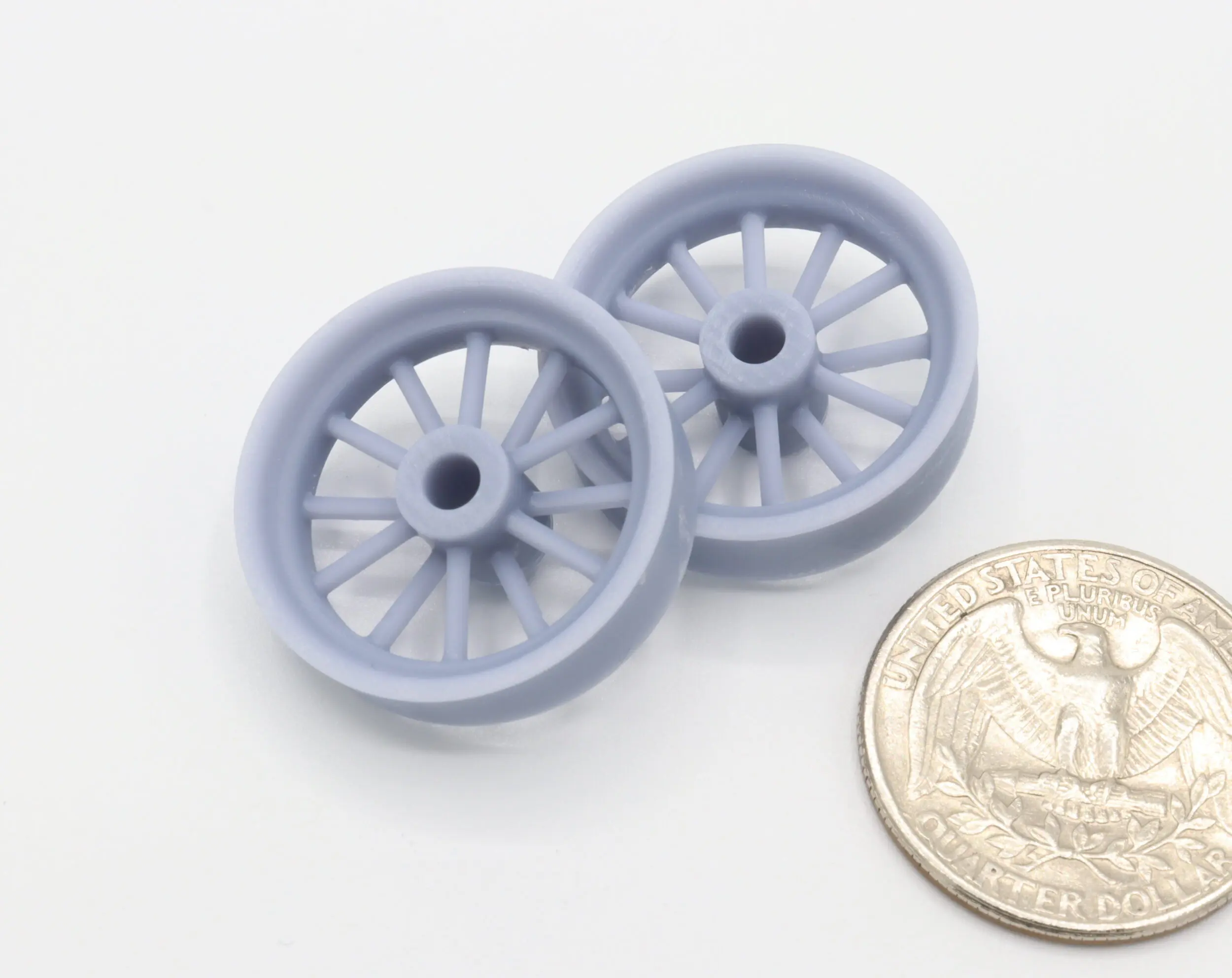 Two small wheels next to a quarter.