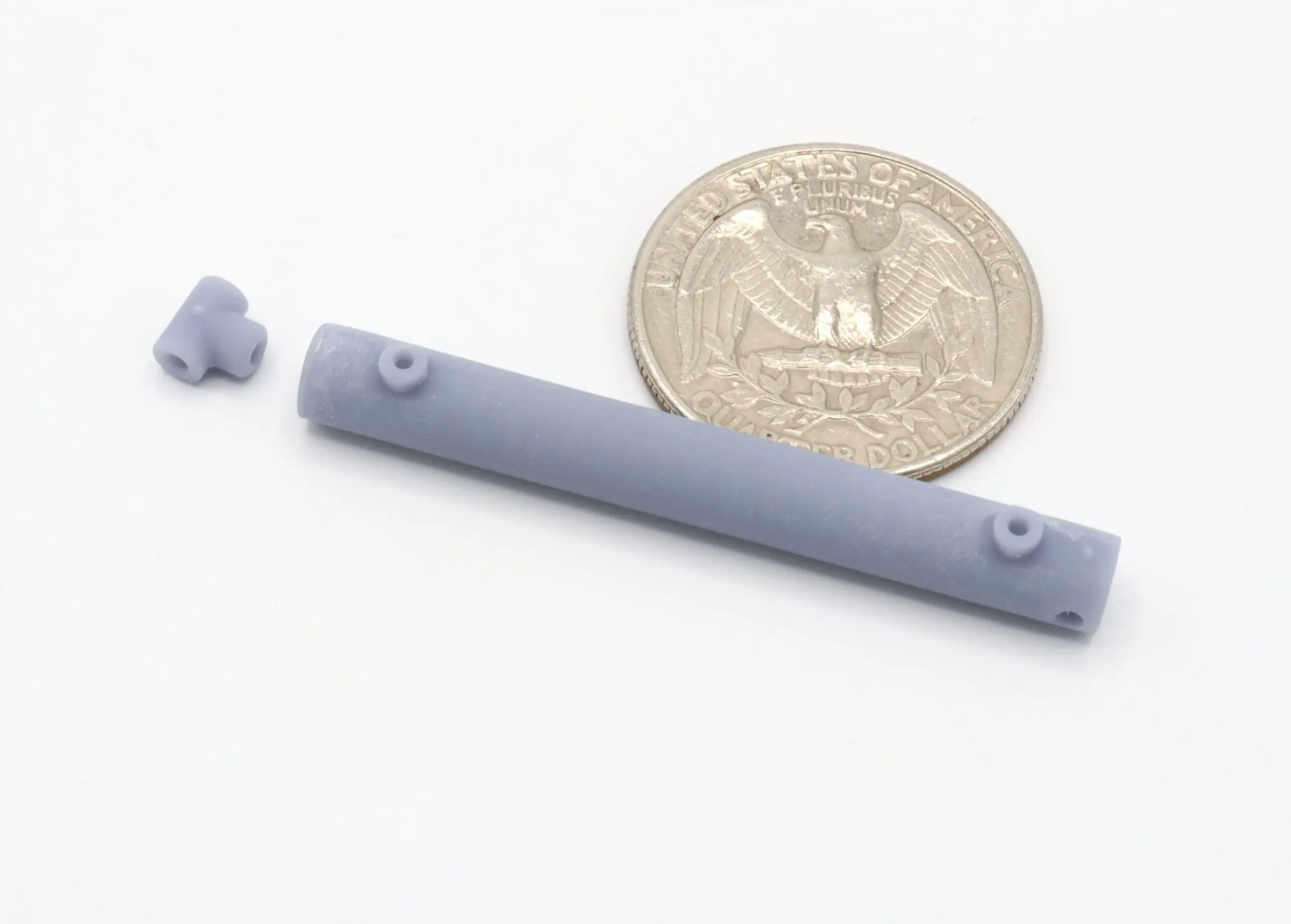 Gray plastic parts beside a quarter coin.
