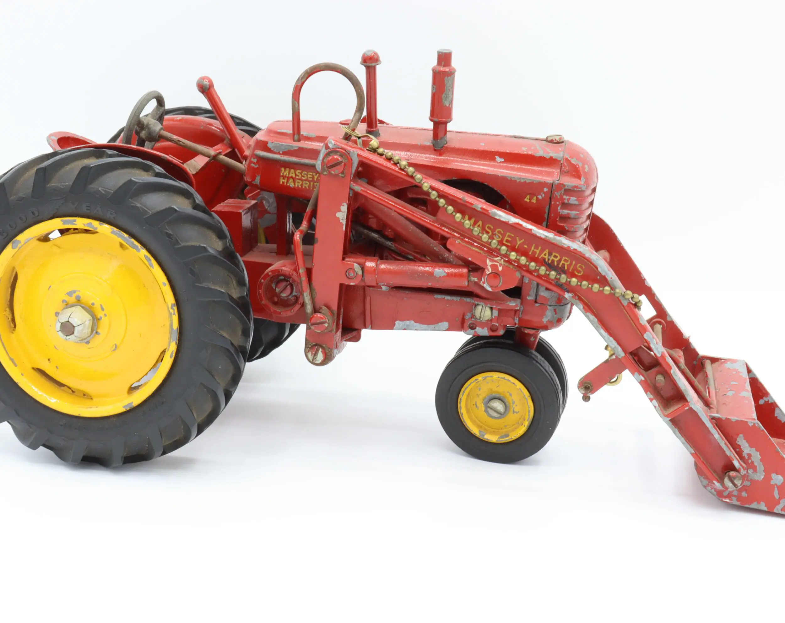 Red toy tractor with yellow wheels.