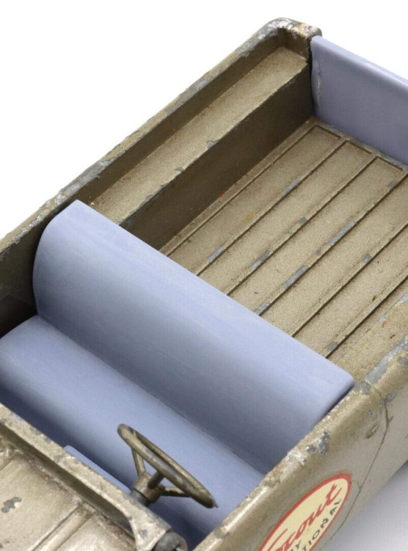 Close-up of a vintage toy truck bed with wooden planks and a rolled tarp.