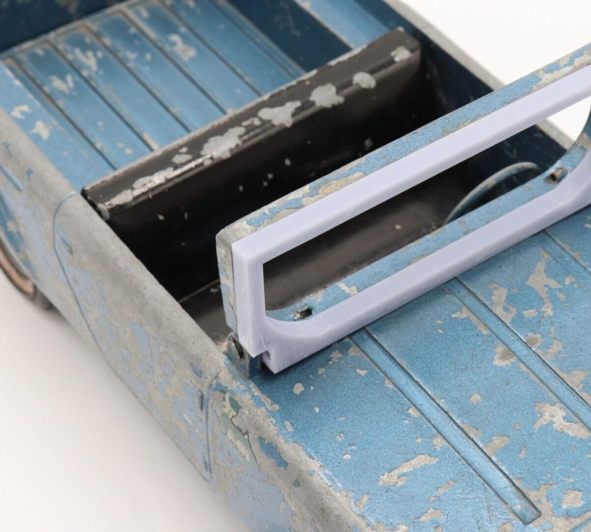 Close-up of a worn blue metal toolbox with a white handle.