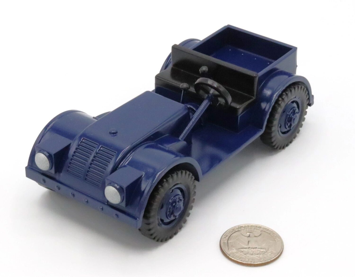 A small blue toy car next to a coin for scale.