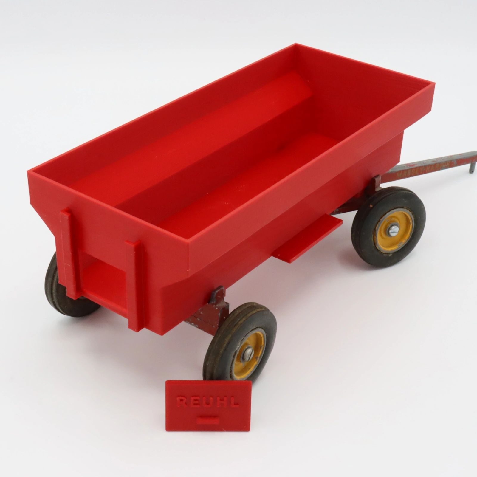 A small red toy wagon with four yellow-rimmed wheels.