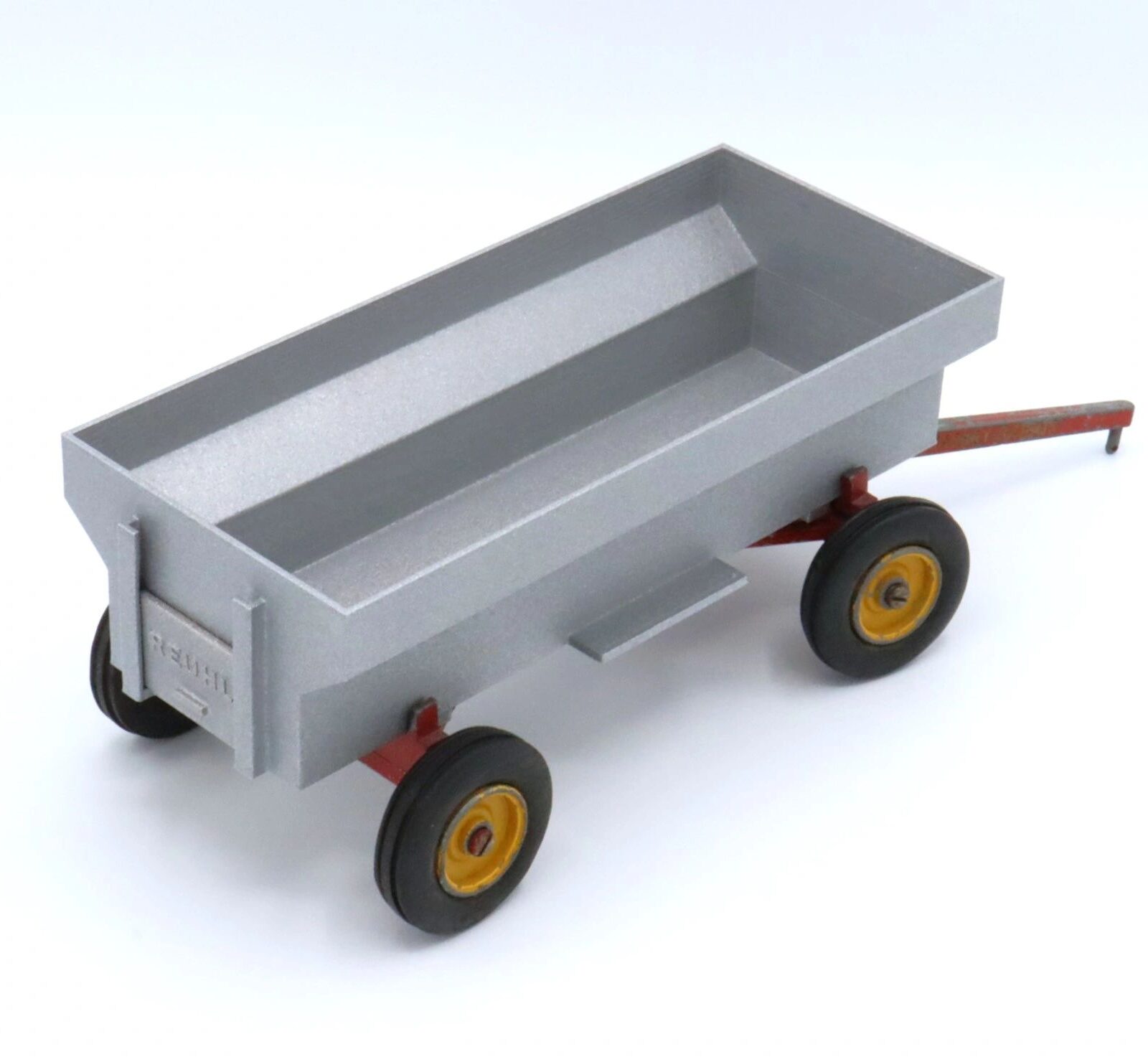 A toy dump truck with a gray bed and black wheels with yellow hubs.