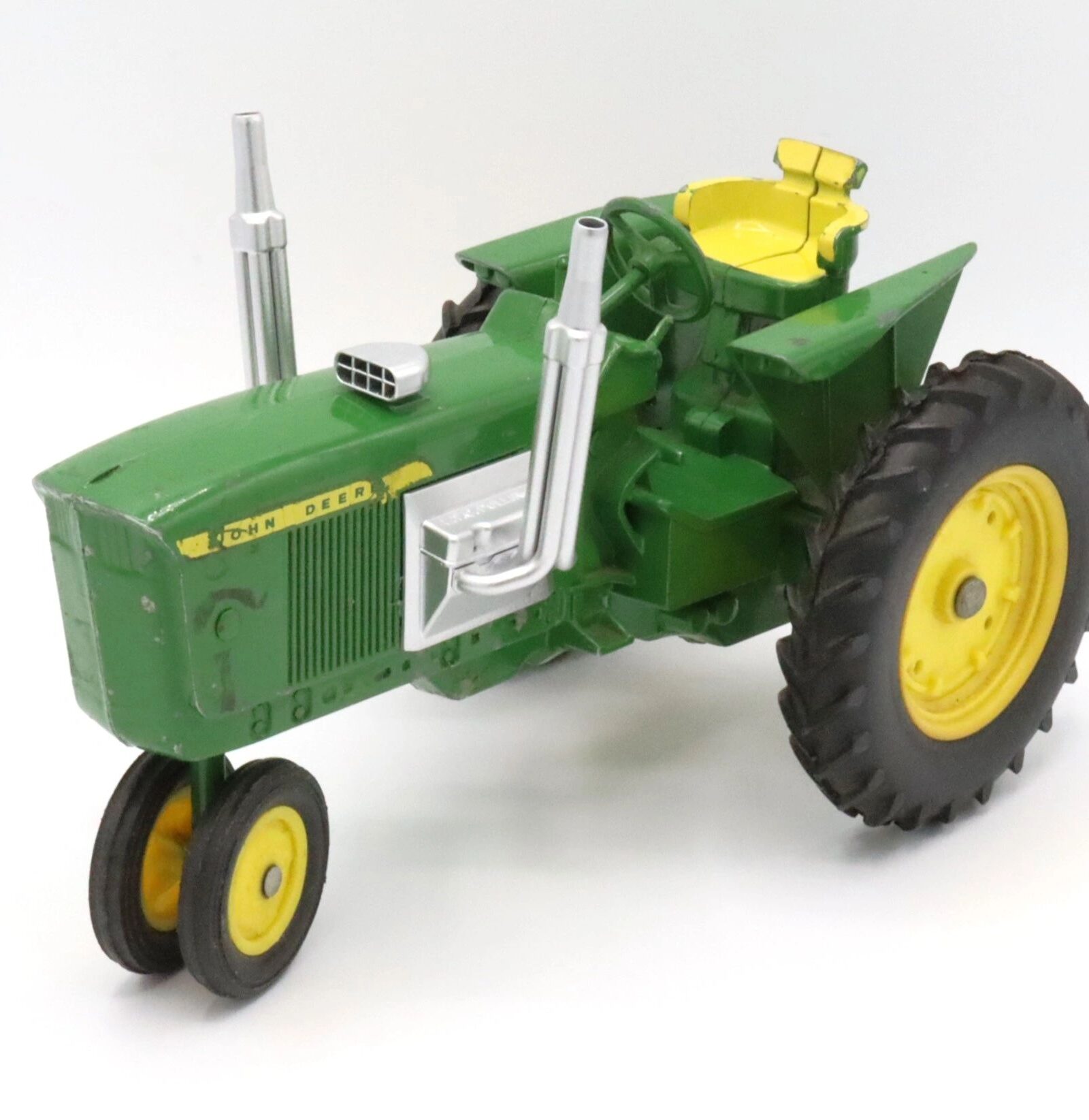 Green and yellow toy tractor with detailed features.