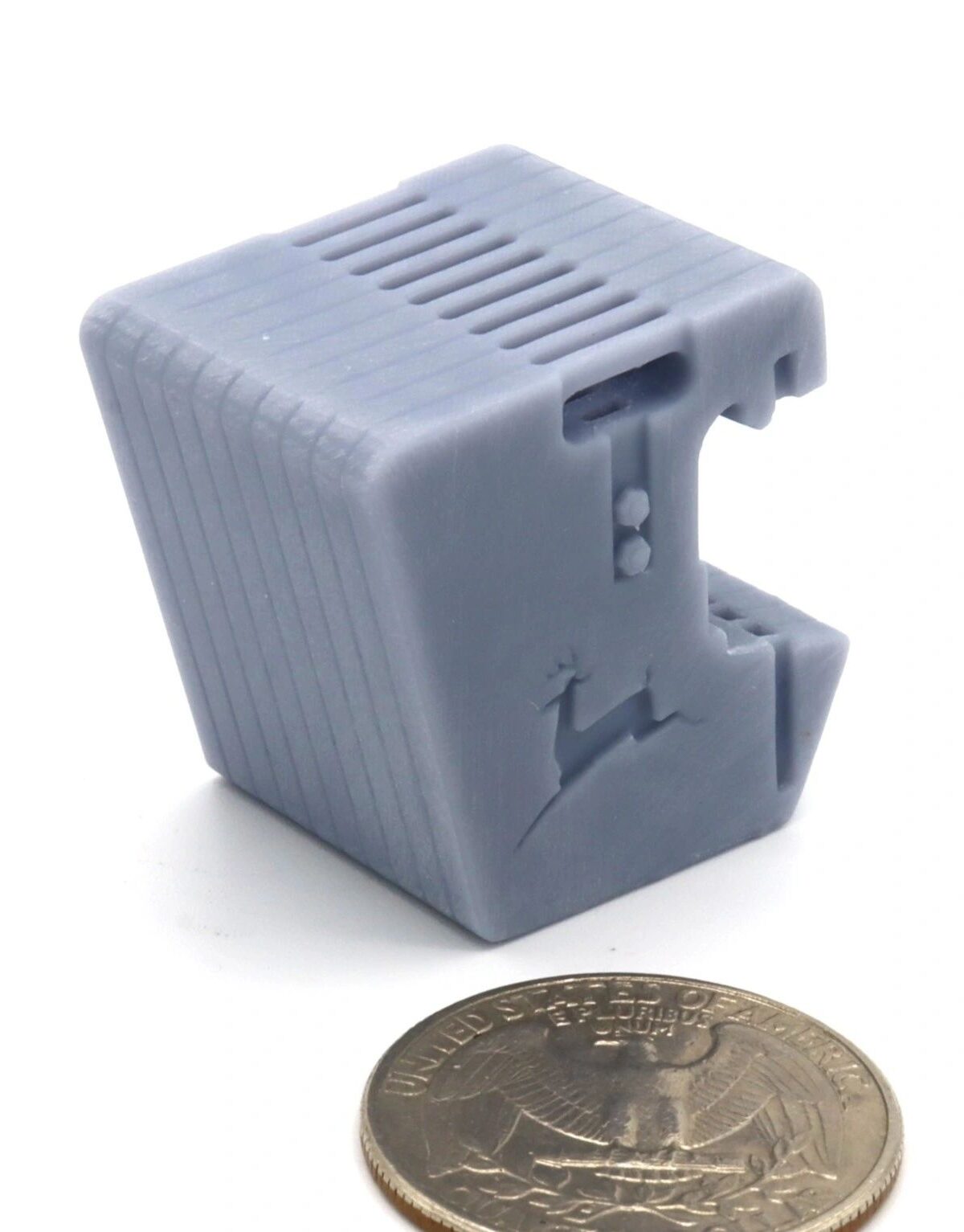 Small gray electronic device next to a coin for scale.