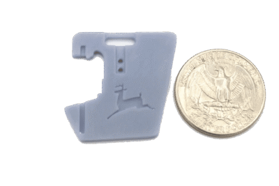 Gray map-shaped piece positioned beside quarter.